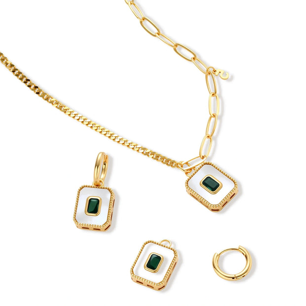 Gold-plated jewelry set with white enamel square pendants and emerald CZ stones on cream background.
