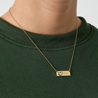 Guldfärgat Mom-halsband buret runt halsen