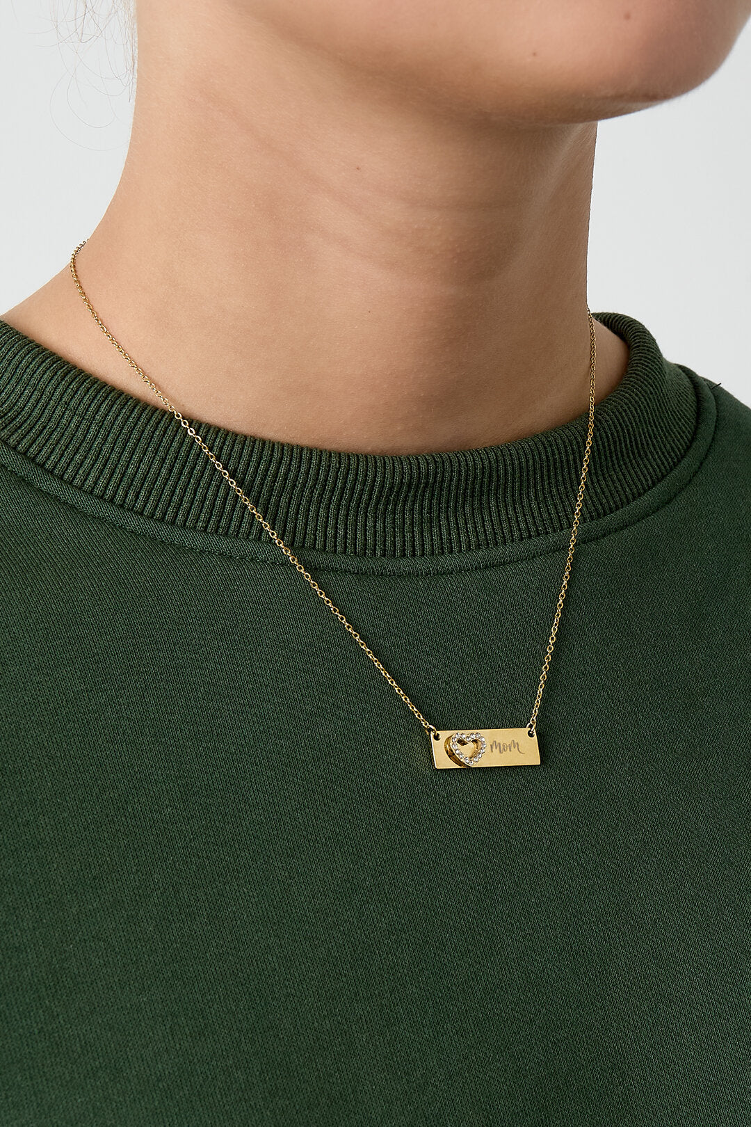 Guldfärgat Mom-halsband buret runt halsen