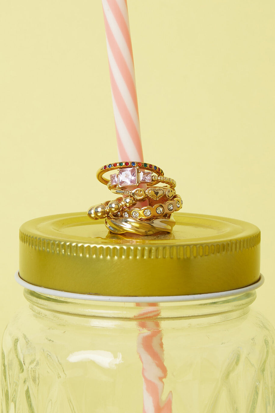 Guldfärgad ring med rosa zirkon kombinerad med andra ringar