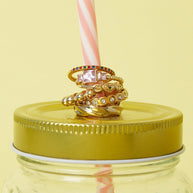 Guldfärgad ring med rosa zirkon kombinerad med andra ringar