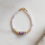 Armband med ametrin och charoit utlagt på ljus stenplatta