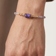 Armband med lila stenar buren på handled