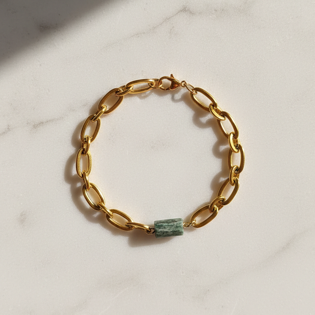 Fuchsitarmband utlagt i cirkel på ljus stenplatta