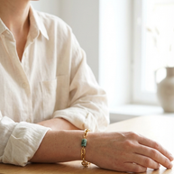 Kvinna som bär fuchsitarmband vid ett ljust bord