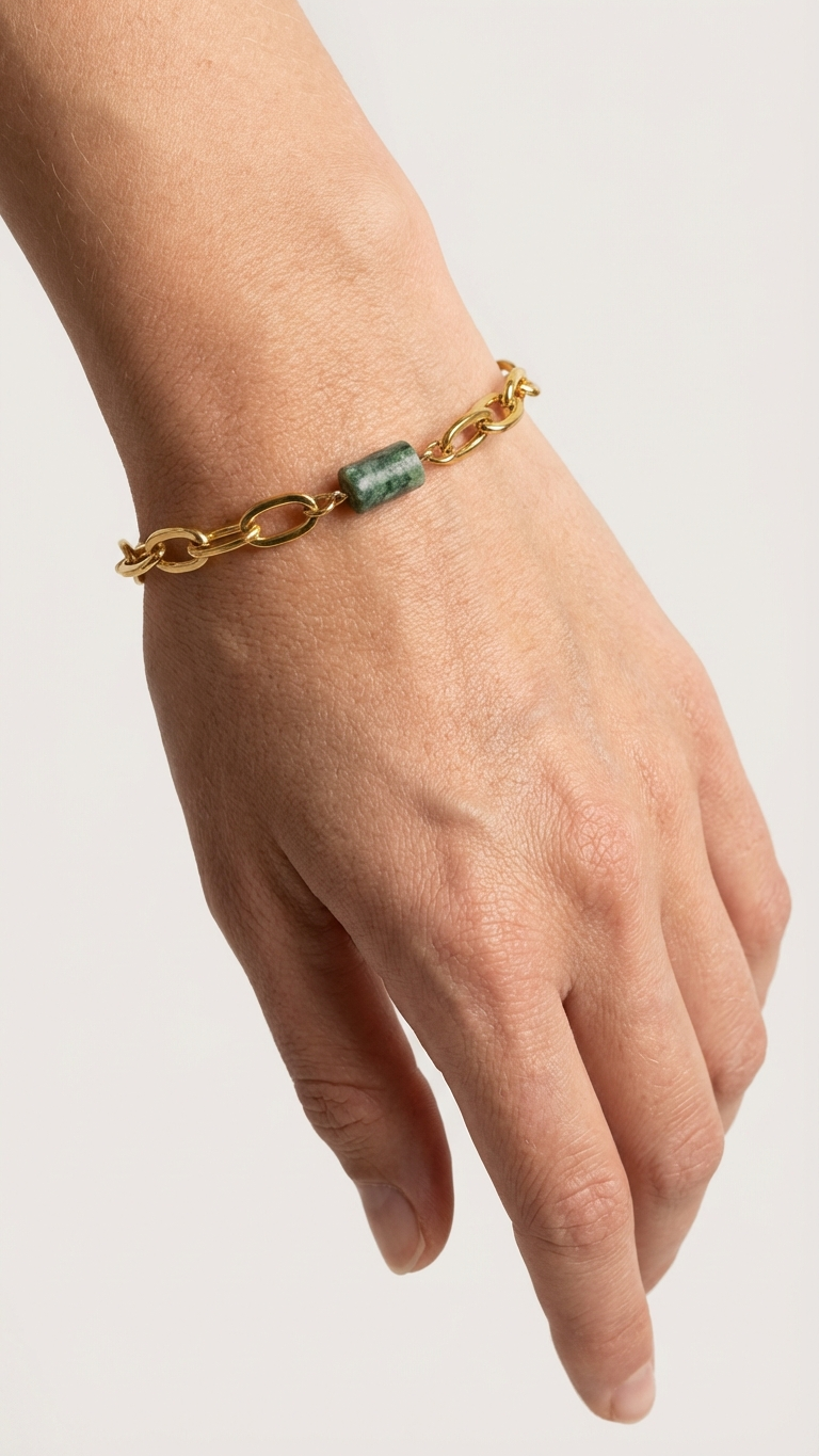 Närbild av fuchsitarmband på handled och vit skjortärm