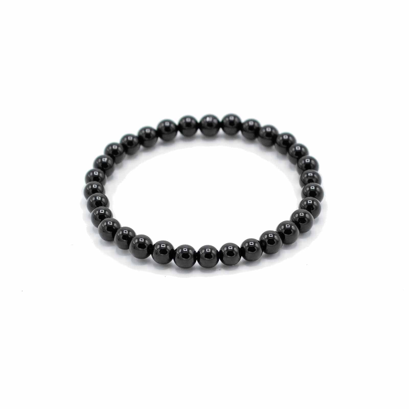 Elastiskt armband med blankpolerade pärlor av svart agat mot vit bakgrund