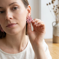 Modell som visar ett rosétonat blomörhänge vid örat
