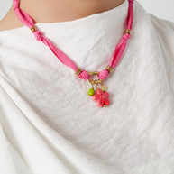 Fuchsia halsband med blomhänge buret runt halsen