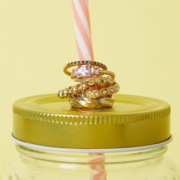 Ring med rosa zirkon kombinerad med andra guldfärgade ringar