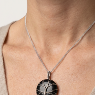 Runt onyxhalsband buret mot beige topp