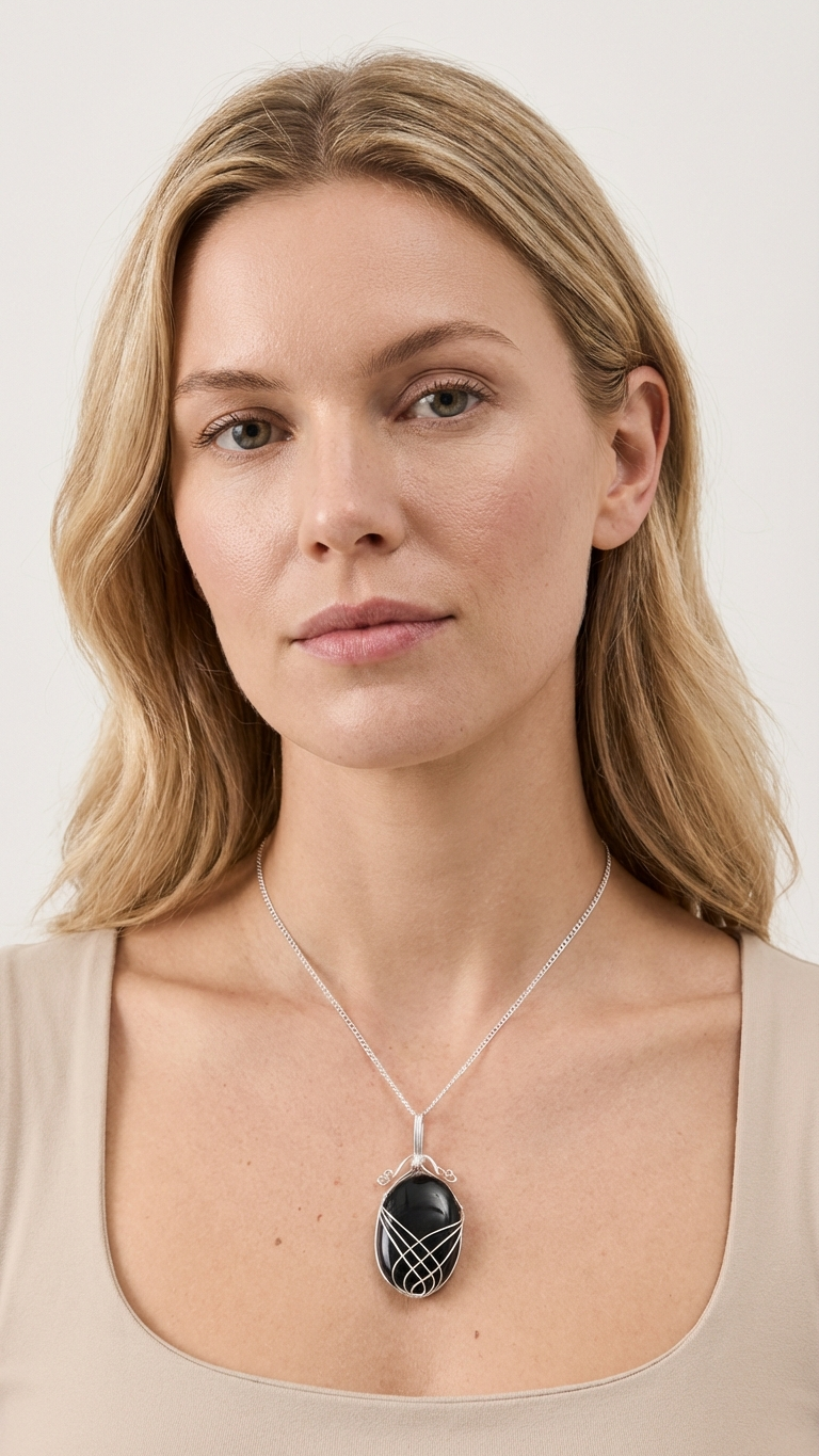 Onyxhalsband med swirltråd buret mot beige topp
