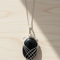 Onyxhalsband med swirltråd utlagt på ljust trä