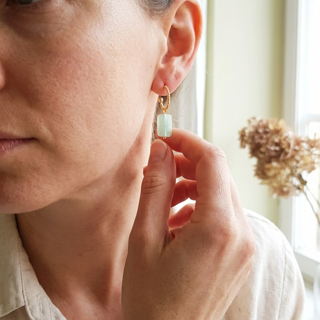 Kvinna som bär liten akvamarincreol i närbild