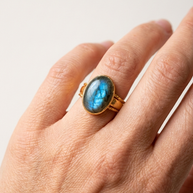 Oval labradoritring buren på finger i närbild