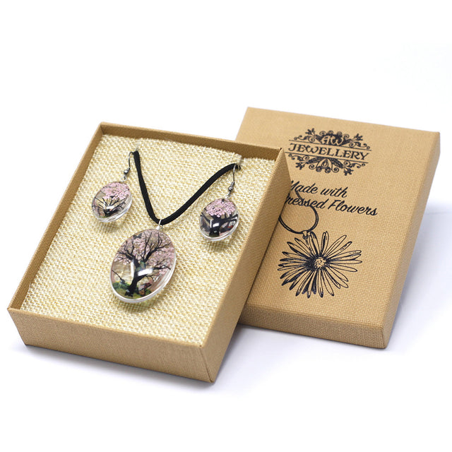 Smyckeset med pressade rosa blommor i presentask