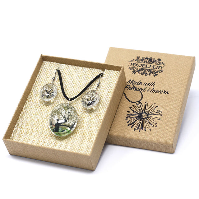 Smyckeset med pressade vita blommor i presentask