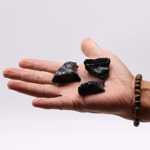 Obsidianbitar visade i en öppen hand